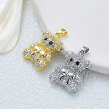 Detailed close-up of 18K gold and silver bear pendants with sparkling crystals