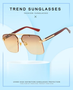 Detail of semi-rimless sunglasses with gold metal frame, brown gradient lenses and UV400