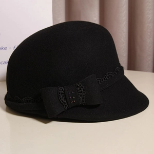 Detailed view of black wool cloche hat featuring a bow with lace trim and colored beads