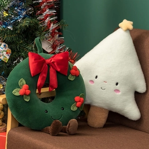 Close-up of plush Christmas tree and wreath pillows with cute faces on a chair