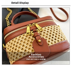 Detail of woven straw and brown leather box bag with gold metal zipper and chain strap