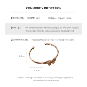 Detailed view of gold-plated butterfly bangle with cubic zirconia on copper base