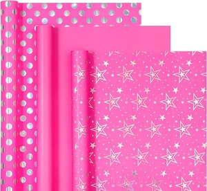 Macro shot of hot pink gift wrapping paper with metallic gold foil dots and stars
