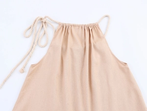 Détail du col d'une robe de plage en lin beige avec cordon décoratif en corde de coton tressé