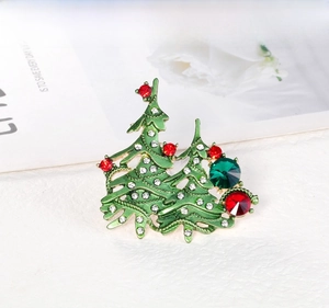 Detailed close-up of green enamel Christmas tree brooch with colorful rhinestones