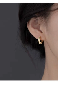 Detailed view of a gold S999 silver C-shaped earring with a unique crushed texture on ear