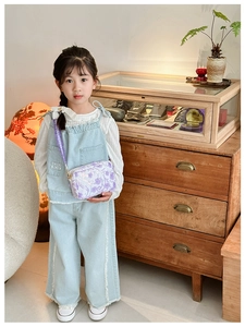 Girl wearing a light purple floral crossbody bag with a 3D flower and woven shoulder strap