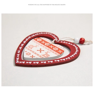 Close-up of Nordic style heart-shaped wooden ornament with red elk and snowflake patterns