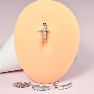 Detailed view of silver stainless steel belly ring with white zircon and colorful opal stone