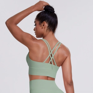 Detail view of the criss-cross back straps on a soft light green sports yoga bra