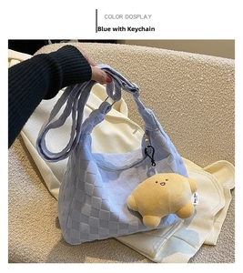 Detail of light blue woven texture tote bag featuring a cute yellow puppy pendant