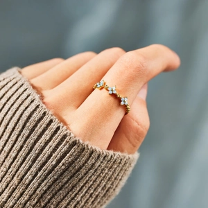 Minimalist S925 sterling silver ring with blue flowers worn on a finger