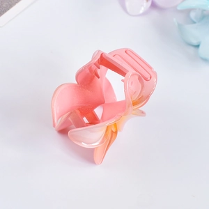 Detail of pink gradient frangipani hair claw clip with pearlescent finish on white background