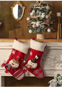 Detail of red felt Christmas stocking with 3D snowman embroidery hanging on fireplace