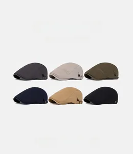 Detail view of cotton flat caps showing decorative side stitching and metal side buckles