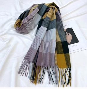 Detailed view of the ginger yellow and lavender plaid faux cashmere scarf with fringe