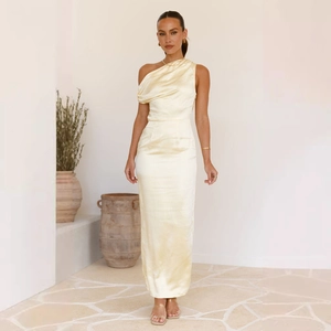 Detail of champagne satin dress showing elegant asymmetrical pleats and silky texture