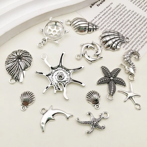 Macro detail of antique silver ocean charms including starfish, turtle and seahorse shapes