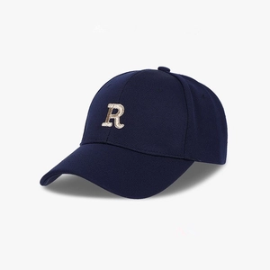 Close-up of navy blue baseball cap featuring detailed golden letter R embroidery on fabric