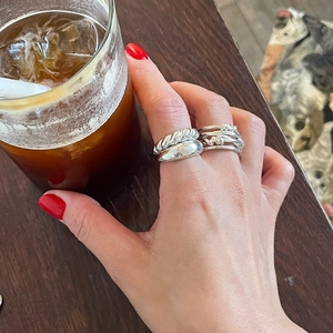 Three stacked 925 sterling silver rings including braided and irregular minimalist designs