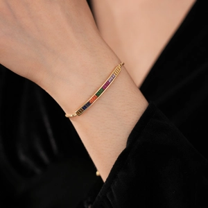 Macro shot of gold-plated bracelet featuring baguette-cut rainbow cubic zirconia stones