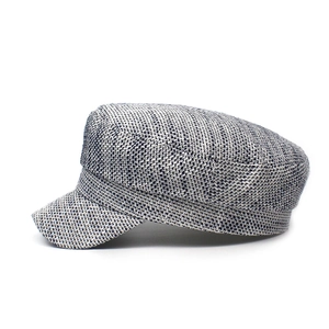 Detail of the woven texture on a black and white flat-top military style newsboy cap