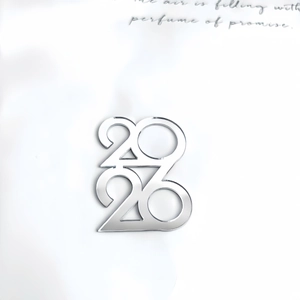 Macro shot of silver 2023 number cake topper in mirrored acrylic for New Year party