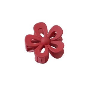 Close-up of red flower-shaped hair claw clip with a matte finish on white background