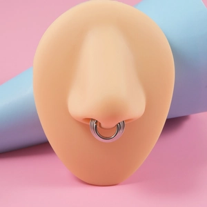 Macro shot of silver multilayer stainless steel nose ring on a silicone model