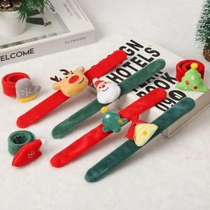 Plush Christmas slap bracelets with reindeer and Santa Claus designs on soft white rug