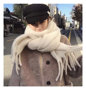Close-up of thick white cashmere-feel scarf with tassels and soft plush texture