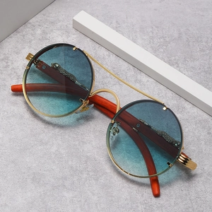 Detalle de gafas de sol redondas sin montura con leopardo metálico y patilla de madera