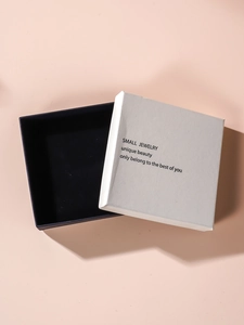 White textured square jewelry box with black interior and small jewelry print