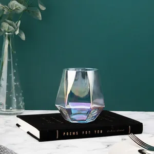 Elegant geometric iridescent glass cup for juice and coffee on a luxury book setting