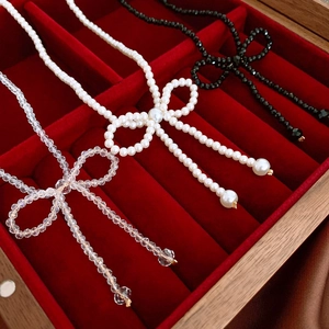 Elegant woven bow choker necklaces with pearls and crystals in a velvet jewelry box