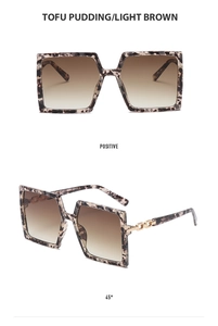 Detail of tortoise frame square sunglasses with chain temple and light brown lenses