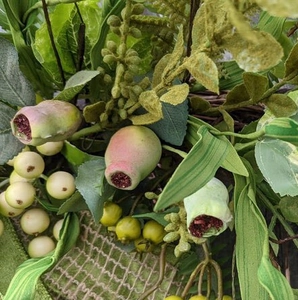 Artificial pastoral wreath with green leaves, yellow berries and rustic linen texture