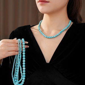 Detailed close-up of natural turquoise beaded necklace with vibrant blue-green gemstones