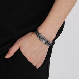 Detail of a silver punk wheat-patterned dragon chain bracelet on a male model wrist