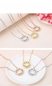 Detailed view of hollow smiley face necklaces in silver, gold, and rose gold finishes