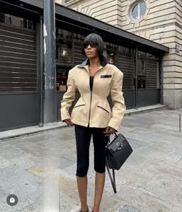 Detail of tailored beige jacket with black leather collar and structured padded shoulders