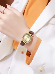 Detail of GEDI square watch featuring gold sunray dial and brown leather strap