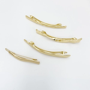 Close-up of four wavy gold metal hair clips for women on a clean white background
