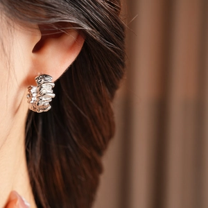 Detail of silver irregular textured hoop earrings on model showing crinkled metallic finish
