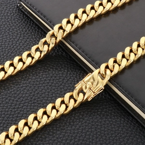 Polished 13mm gold stainless steel Cuban link chain for men on black leather background