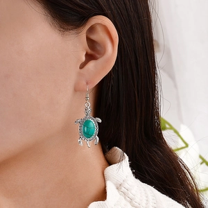 Bohemian silver turtle earrings with green turquoise on model for a vintage look