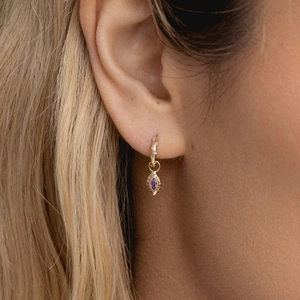 Detail of S925 silver hoop earrings with purple marquise stone and gold finish
