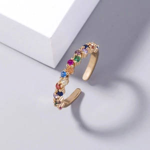 Detailed shot of gold open ring featuring a row of vibrant rainbow zircon stones