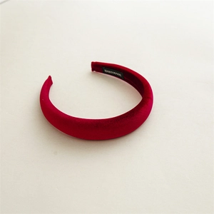 Close-up of thick red velvet headband with high-quality handmade label detail