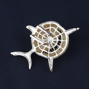 Detailed back view of a silver shark skeleton brooch showing the metal pin mechanism